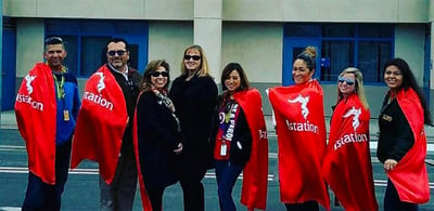 Istation educators in red capes being superheros