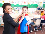 Teacher with student in cape.