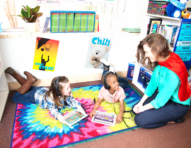 Boy and a girl reading on iPads with teacher