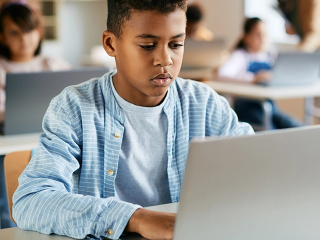 Boy-Student-Blue-Button-Shirt-Laptop-Classroom-640x480