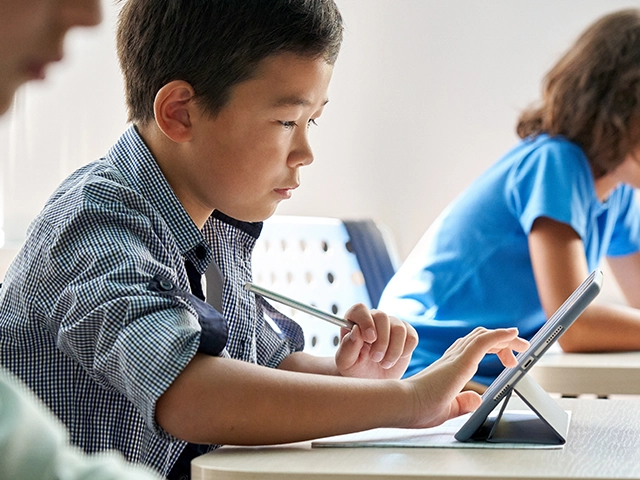 Boy-Student-Sitting-Tablet-Classroom-640x480
