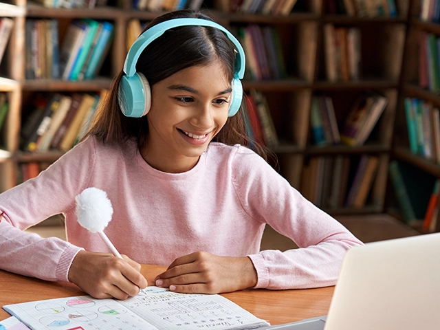 Student working with headphones and laptop